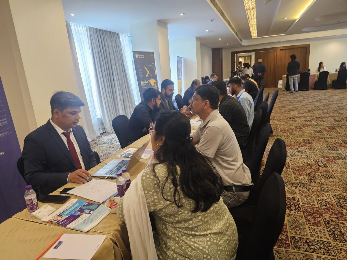 A family speaking with an international university representative at an education event